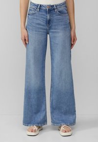 Jean large bleu clair en denim, doté de cinq poches, d'une fermeture à bouton et d'un ourlet bien coupé.