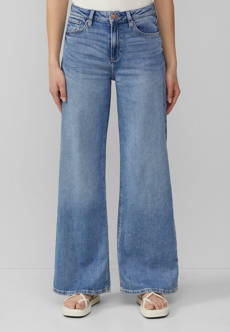 Jean large bleu clair en denim, doté de cinq poches, d'une fermeture à bouton et d'un ourlet bien coupé.