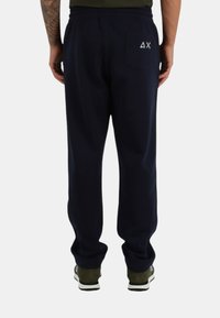 Pantaloni della tuta blu navy realizzati in tessuto morbido, con cintura elastica, tasca laterale e piccolo logo sul taschino posteriore.
