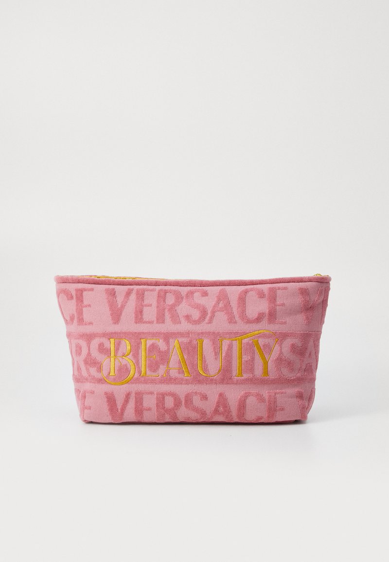 Rosa tygpås med plyschtextur, med präglad "VERSACE"-mönster och djärv gul "BEAUTY"-text framtill. Dragkedja upptill.