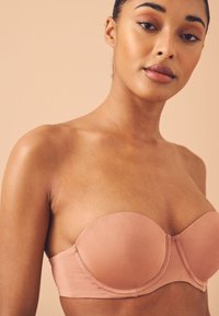 Roze strapless bh met een zachte satijnen afwerking, voorzien van voorgevormde cups en een gestructureerd ontwerp voor ondersteuning.