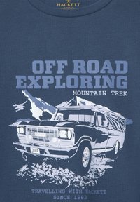 Tmavě modré tričko s grafikou vintage terénního auta a horami v pozadí. Text zní "ODVAHA V TERÉNU - HORSKÝ VÝLET."