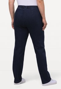 Mörkblå denimjeans med avslappnad passform, featuring ett elastiskt midjeband och rak benstil, med minimal sömnadsdetalj.