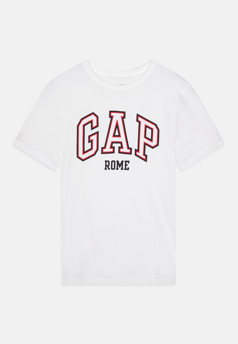 T-shirt alb din bumbac, cu inscripția "GAP" în roșu cu contur negru și "ROME" în negru îngroșat. Maneci scurte și design cu gât rotund.