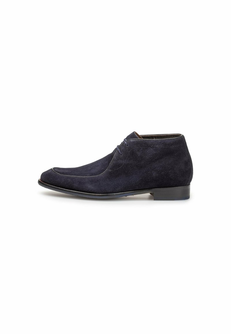 Botas de tobillo de ante en color navy con punta redonda, cordones en la parte delantera y un tacón bajo negro. Textura suave con un sutil detalle de costura.