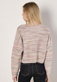 Crochet-style sweater in multi-color tones of pink, beige, and green with a loose fit, ribbed details, and cropped length.