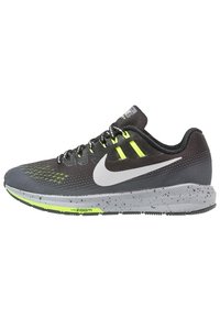 Chaussure de course Nike en maille noire avec des accents vert lime, présentant un swoosh blanc distinctif, une semelle intermédiaire grise tachetée et un dessus texturé.