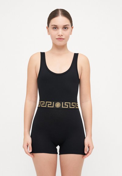Body negru cu decolteu rotund și picioare scurte, accentuat cu o curea cu model aurie care prezintă un medalion și un design cu chei grecești.