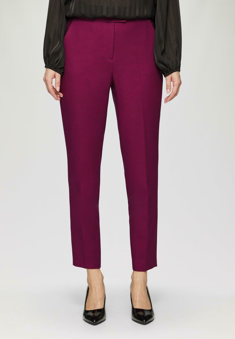 Pantalons ajustés magenta avec une coupe slim, dotés d'un devant plat, de poches latérales et d'une texture de tissu lisse.