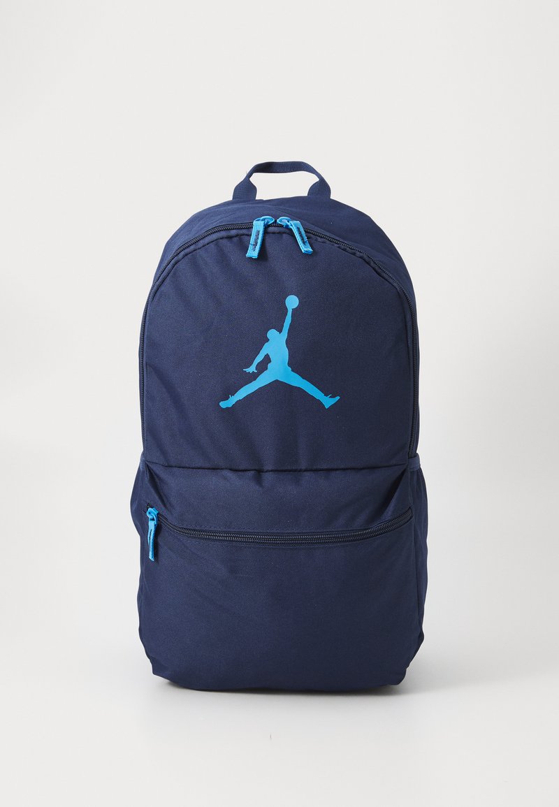 Navy blue backpack with light blue zipper pulls and a light blue silhouette of a basketball player mid-jump holding a ball.
