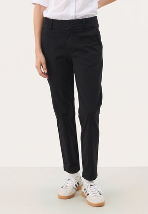 Black cotton trousers with a slim fit, featuring a flat front, side pockets, and a smooth, matte texture. Worn with white sneakers.