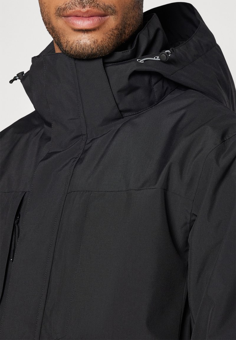Schwarz wasserdichte Jacke mit hohem Kragen, verstellbarem Kordelzugkapuze, Fronttasche und glatter, matter Oberfläche. Reißverschlussdetails sichtbar.