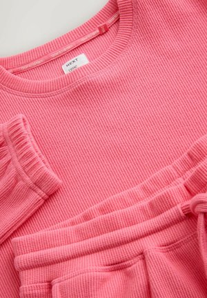 Pink ribstrikket sweater og matchende bukser. Blød tekstur, rund halsudskæring og elastiske manchetter. Mærkeetiket synlig på sweateren.