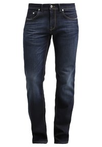 Mörkblå slim-fit jeans med framfickor, bältesöglor och blekta detaljer på låren och knäna, visas utan modell.