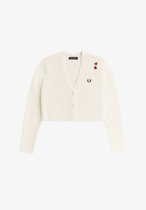 Cardigan blanco corto con escote en V, tres botones, pequeño logo de laurel negro en el pecho y dos parches rojos de corazón en el hombro izquierdo.