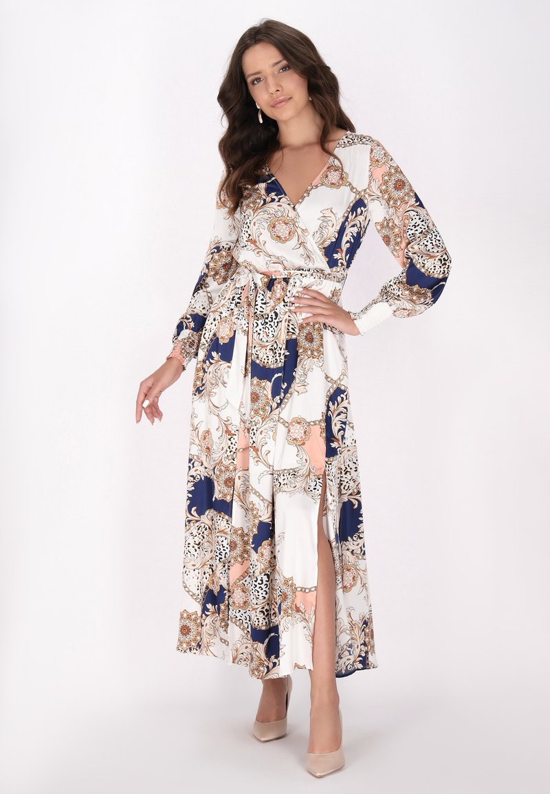 Abito lungo avvolgente bianco con intricate fantasie floreali in navy, oro e pesca. Caratterizzato da maniche lunghe, vita con lacci e uno spacco alto fino alla coscia.