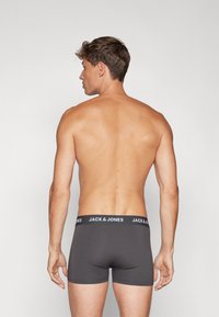 Grau Boxershorts mit taillierter Passform, ausgestattet mit einem schwarzen Bund, auf dem "JACK & JONES" steht. Glattes Material, minimale Nähte und ohne Muster.