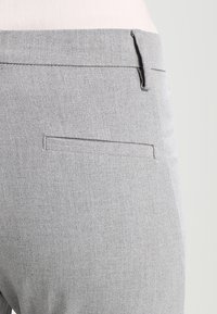 Šedé kalhoty s texturovanou látkou, slim fit střihem, jednou zadní kapsou a čistým pasem pro upravený vzhled.