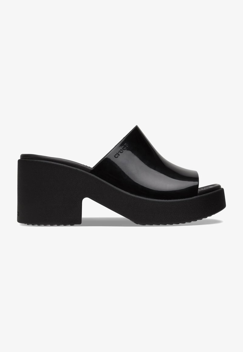 Slides plateformes noires avec une tige lisse et brillante et une semelle texturée. Le design comprend un bout ouvert et une large bride traversant le pied.