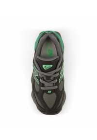 Scarpa sportiva grigia con accenti verdi, dotata di tomaia in rete, lacci, linguetta imbottita e suola testurizzata progettata per comfort e stabilità.