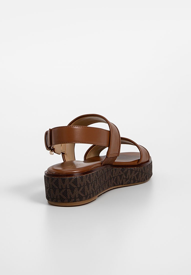 Sandali piattaforma in pelle marrone con due ampie cinghie e una fibbia regolabile. La base testurizzata di un marrone scuro presenta un motivo con logo.