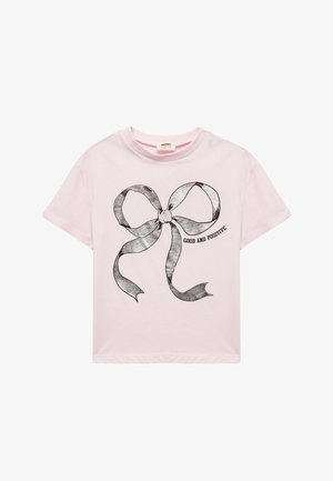 Lichtroze katoenen t-shirt met een zwarte omtrekafbeelding van een strik en de tekst "GOED EN POSITIEF" in een eenvoudig lettertype. Korte mouwen.