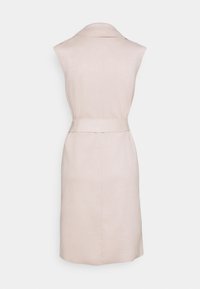 Jasnobeżowa, bezrękawna sukienka z gładkiej tkaniny, z kołnierzem, paskiem w talii i prostą sylwetką bez widocznych zapięć.