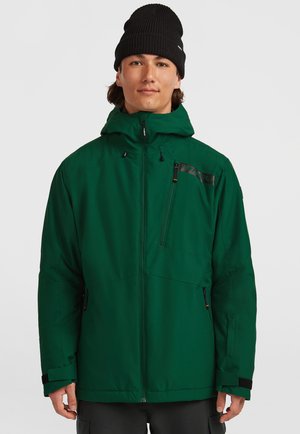 Veste verte isolée avec capuche ajustable, zip frontal et poches zippées. Comprend un logo noir et des poignets ajustables en Velcro.