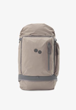 Beiger und grauer Rucksack mit vorderer Reißverschlusstasche, zwei runden schwarzen Logopunkten, gepolstertem Boden und Seitenfächern.