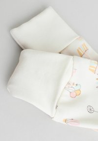 Calzini di cotone con stampe giocose nei colori pastello che raffigurano palloncini e giocattoli. Design con risvolto e texture morbida e liscia. Colore: crema.