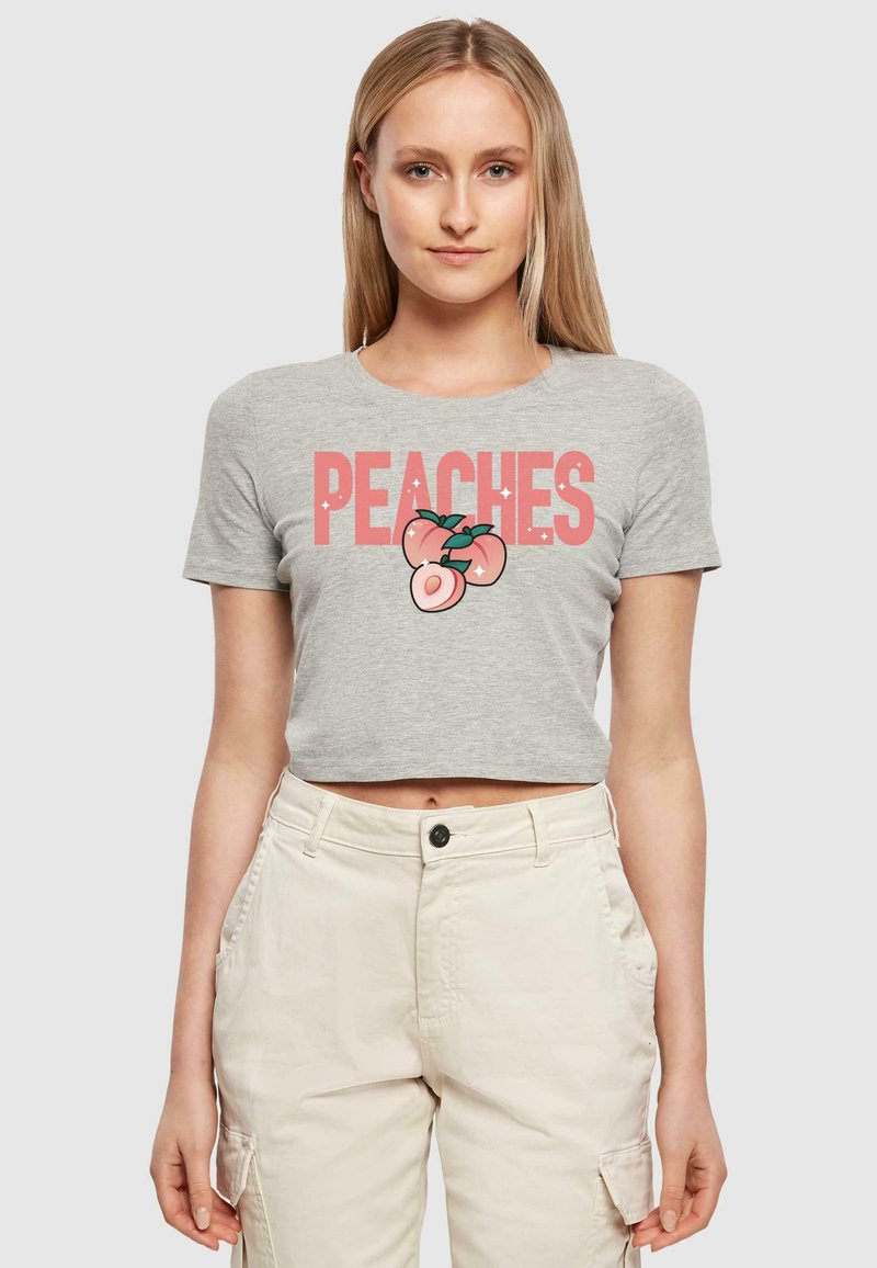 Pilkas trumpas marškinėliai su žodžiu "PEACHES" rožine spalva ir persiko grafika apačioje. Pagaminti iš minkštos medvilnės, skirti kasdieniam dėvėjimui.