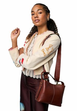 Flødefarvet cardigan med farverig broderi, kombineret med en brun skuldertaske i læder. Tasken har en glat tekstur og guldfarvede detaljer.