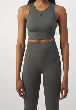 Olivgrüner Sport-BH und hoch taillierte Leggings aus dehnbarem Stoff. Verfügt über eine gerippte Textur und ein Logo auf der Vorderseite des Tops.