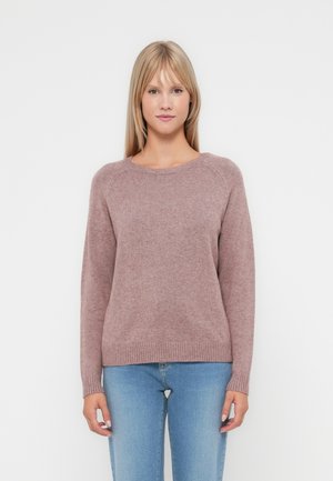 Ribbete crew-neck genser i myk mauve stoff. Har lange ermer og en avslappet passform, sammen med lyseblå jeans.