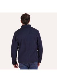 Navy blue fleece jacket with a high collar and contrasting shoulder panels. Features long sleeves and a textured finish. Back view.