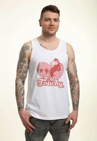 Camiseta sin mangas blanca con un gráfico rojo y rosa que presenta una llama de dibujos animados y el texto "No Touchy" en una fuente divertida. Unos jeans oscuros complementan el conjunto.