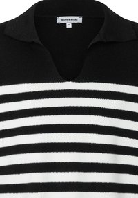 Zwart-wit gestreepte trui met V-hals en kraag. Gebreide structuur met afwisselend dikke en dunne strepen. Merklabel zichtbaar bij de halslijn.