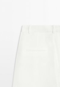 White tailored trousers showing the back waistband with belt loops and a single welt pocket centered below.