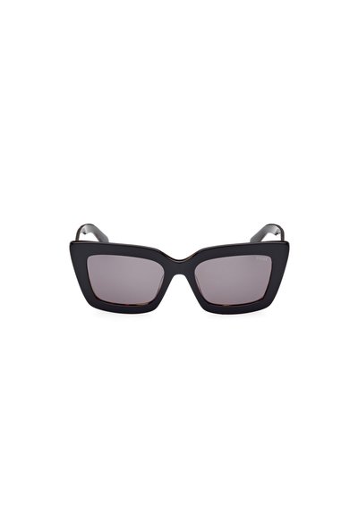 Gafas de sol de ojo de gato con montura negra mate, lentes de degradado púrpura, ángulos marcados y finos acentos de metal a lo largo del borde superior.