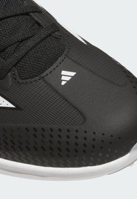 Black athletic shoe with a textured upper, featuring ventilation holes, black laces, and white accents, including a logo and design lines.