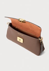 Braune Lederhandtasche mit glattem Äußeren, beigem Wildleder-Innenraum, goldenen Beschlägen und einer Reißverschlusstasche; verfügt über einen quadratischen Verschluss und Kettendetails.