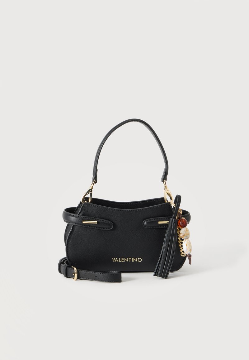 Μαύρη τσάντα Valentino με χρυσό λογότυπο, επάνω λαβή, λουρί ώμου, φούντα και χρυσό γούρι με χάντρες και κοχύλια, σε λευκό φόντο.