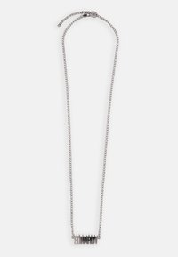 Collana in argento con un pendente audace e frastagliato che riporta la parola "HARDY" in un font unico. Design elegante e moderno con texture contrastanti.