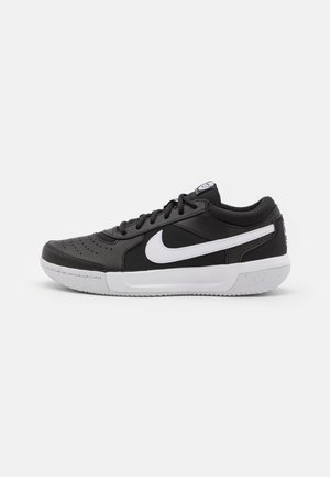 Baskets Nike noires avec une tige texturée, logo swoosh blanc, col rembourré, perforations pour la respirabilité et une semelle blanche mouchetée.