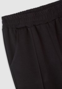 Pantaloni sportivi neri con vita elasticizzata, tasche laterali e una consistenza morbida e liscia. Il tessuto ha una finitura opaca.