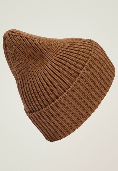 Bonnet en tricot brun avec un sommet pointu, présentant une texture côtelée et un revers plus épais. Le matériau semble doux et flexible.