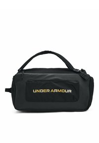 Sac de sport noir avec une texture lisse, comportant une poche avant et un logo doré "UNDER ARMOUR". Inclut une poignée supérieure et une sangle ajustable.