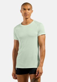 Light green athletic t-shirt with short sleeves, round neckline, and a breathable fabric texture. Features a small logo on the chest.