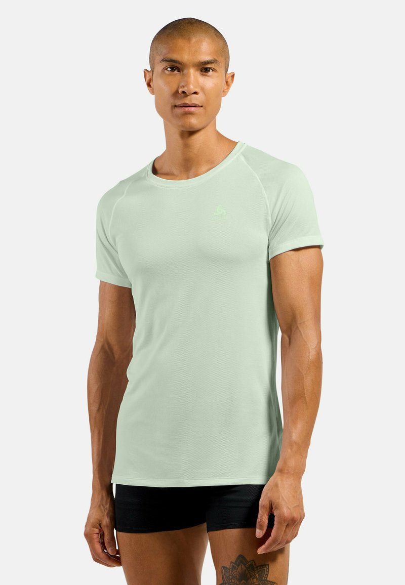 Light green athletic t-shirt with short sleeves, round neckline, and a breathable fabric texture. Features a small logo on the chest.