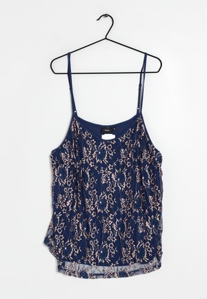 Marineblauwe camisole met een delicate kant overlading met bloemmotieven in lichtbeige. Verstelbare spaghettibandjes en een gebogen zoom.